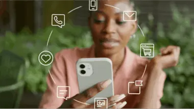 Woman using a smartphone with digital icons for messaging, email, shopping, and social media surrounding her.