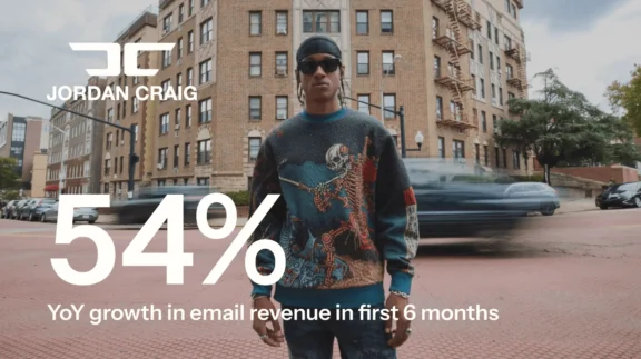 Person in a graphic sweater stands on a city street. Text: "Jordan Craig 54% YoY growth in email revenue in first 6 months.