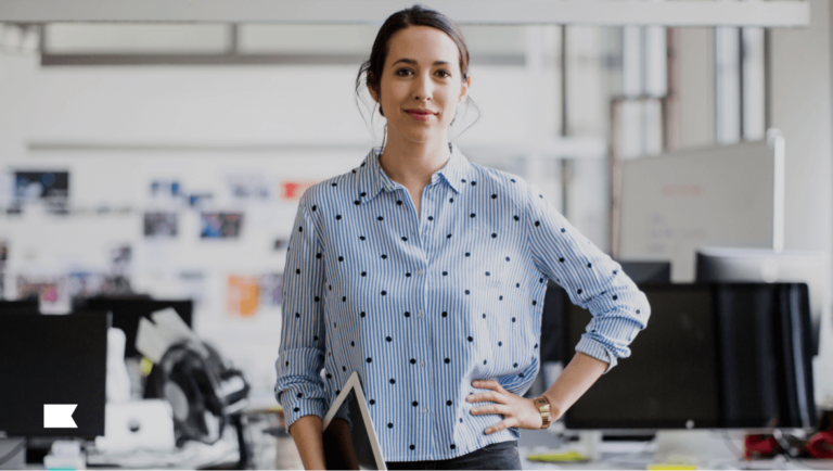 Person standing with hand on hip in an office