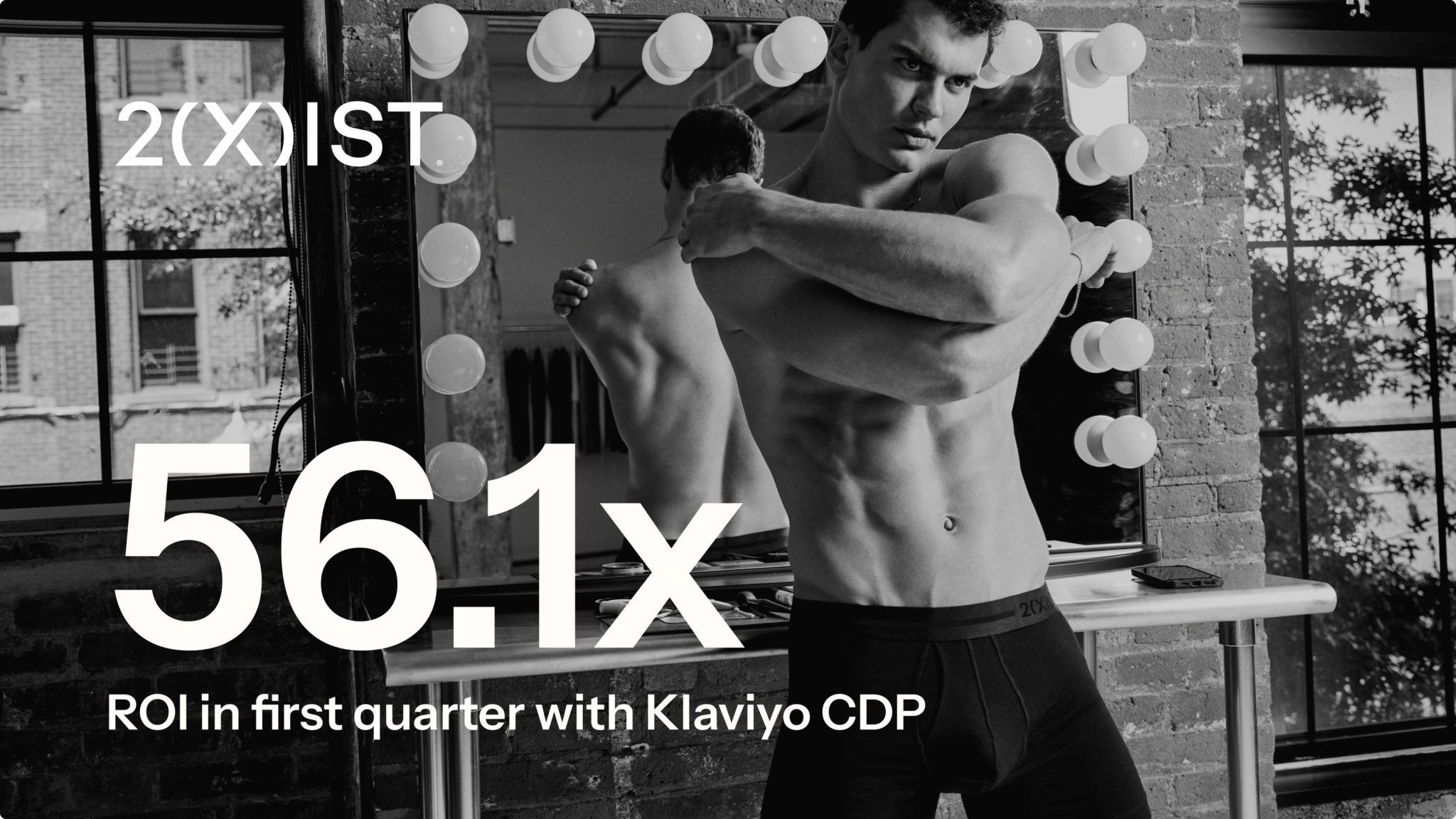 Black and white image of a male model in 2(X)IST underwear posing in front of a mirror, with bold text overlay stating '56.1x ROI in first quarter with Klaviyo CDP.'