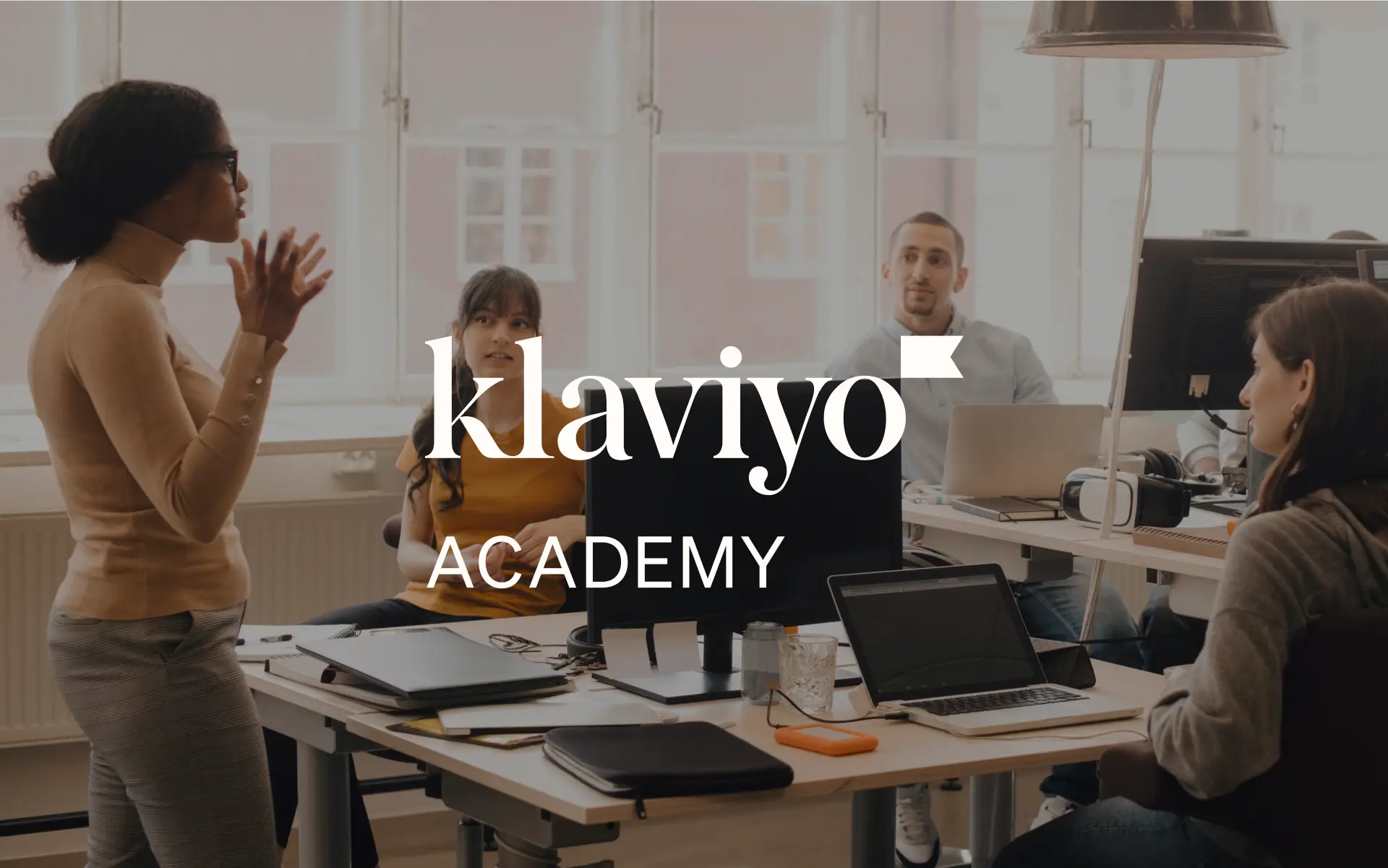 Office setting with a diverse team collaborating, overlaid with "Klaviyo Academy" branding.