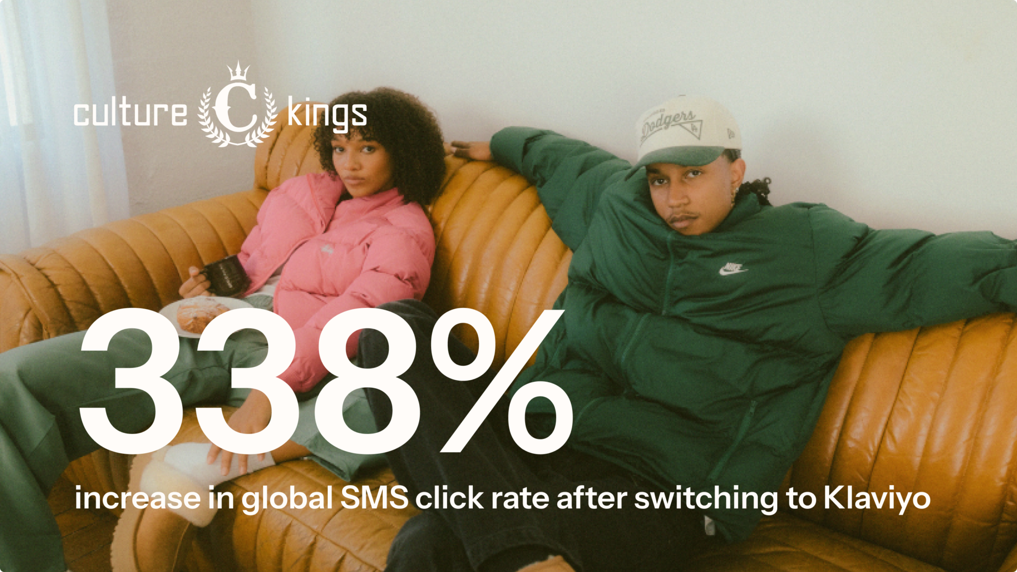 Image with the text "culture kings" and "338% increase in global SMS click rate after switching to Klaviyo" showing two people on a couch.
