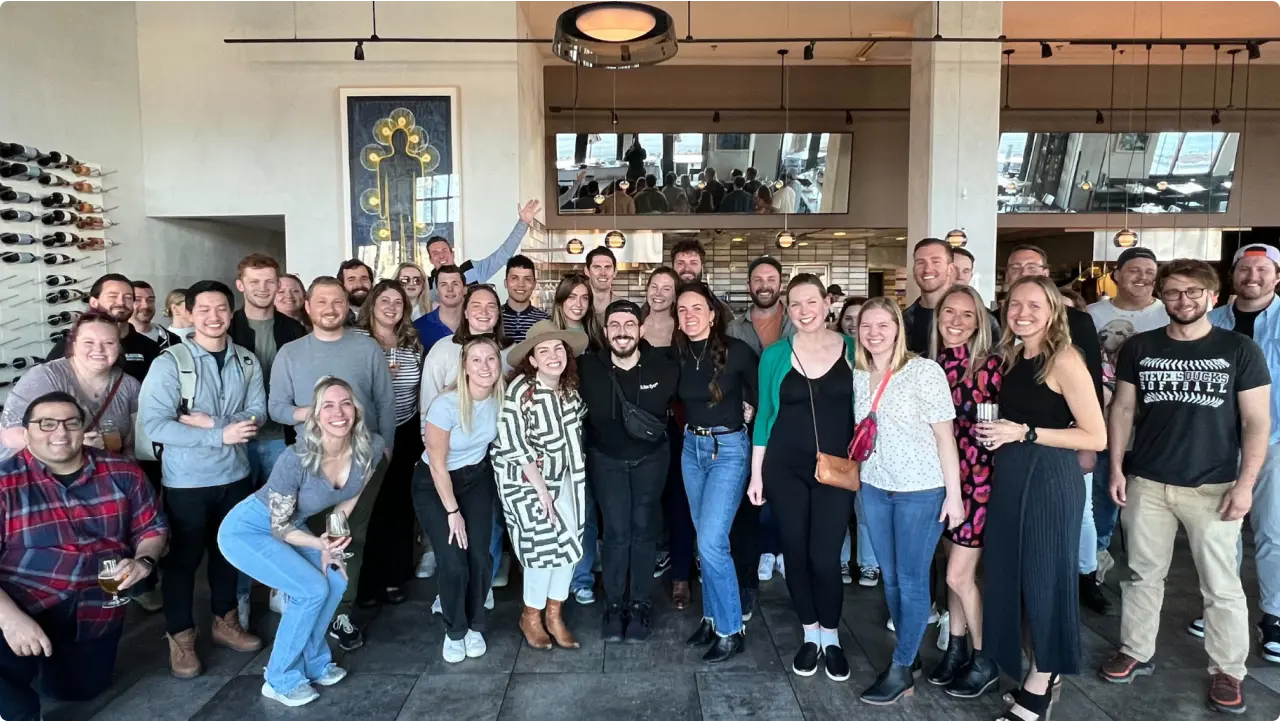 Klaviyo employees, drinks in hand, pose during an after-work outing in Denver